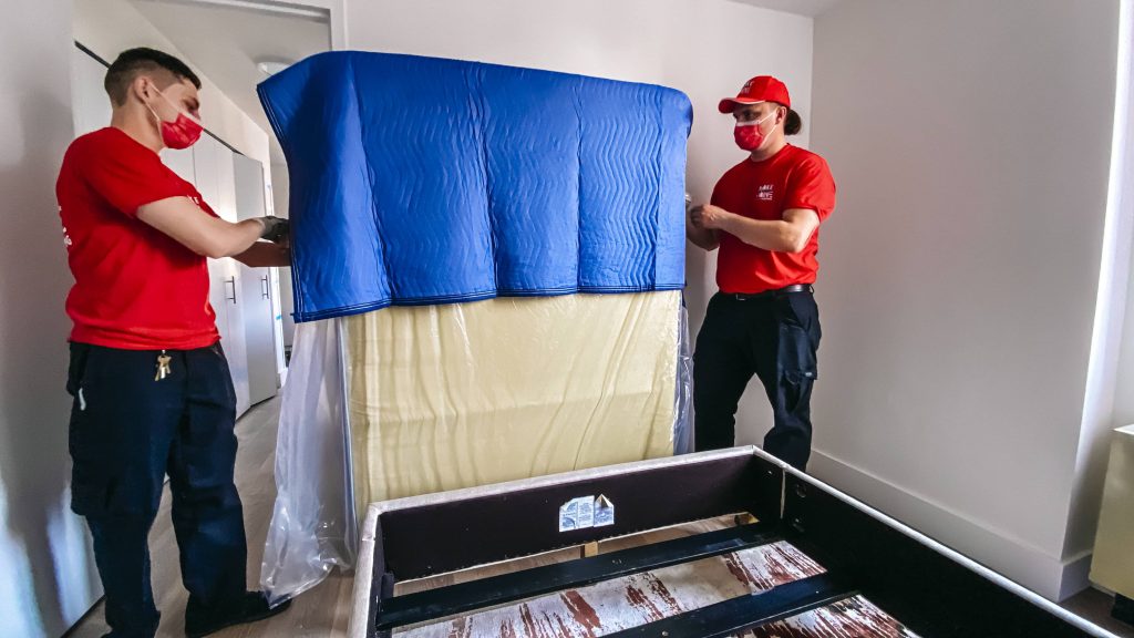 moving team wrapping a mattress 