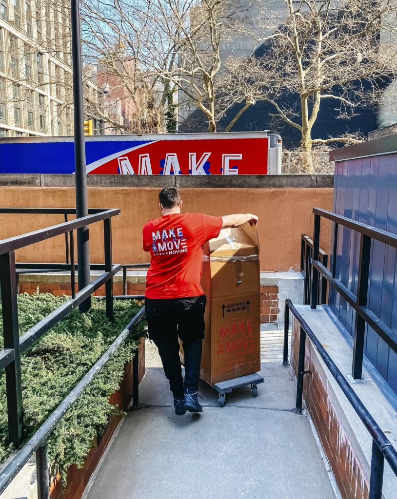 guy moving a box using a cart