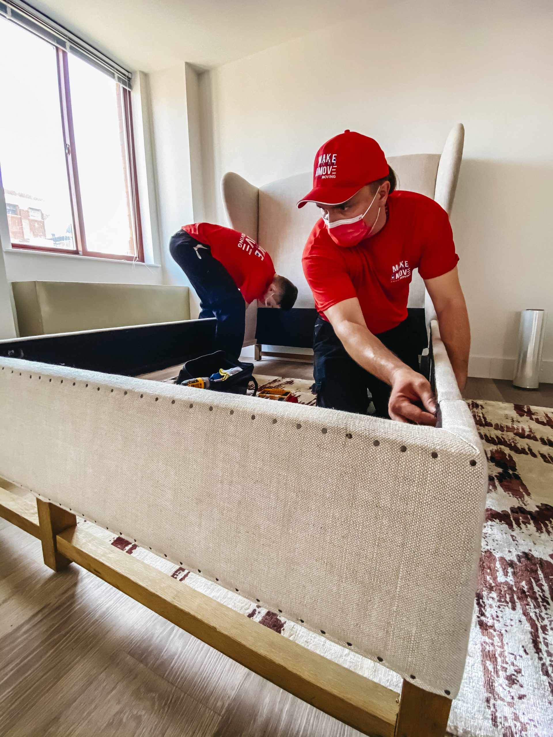 2 guys disassembling a bed frame