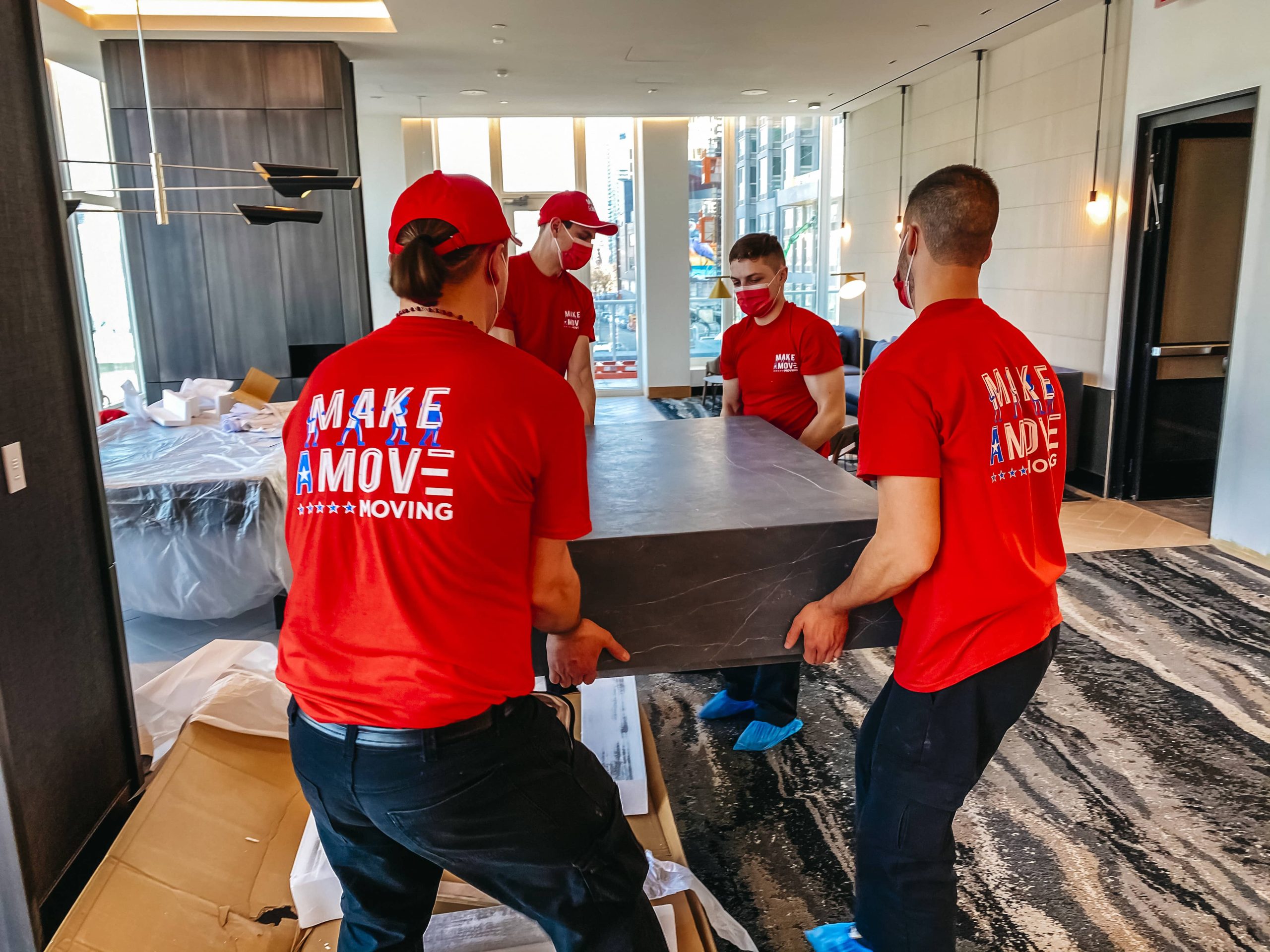 Four men carrying a coffee table